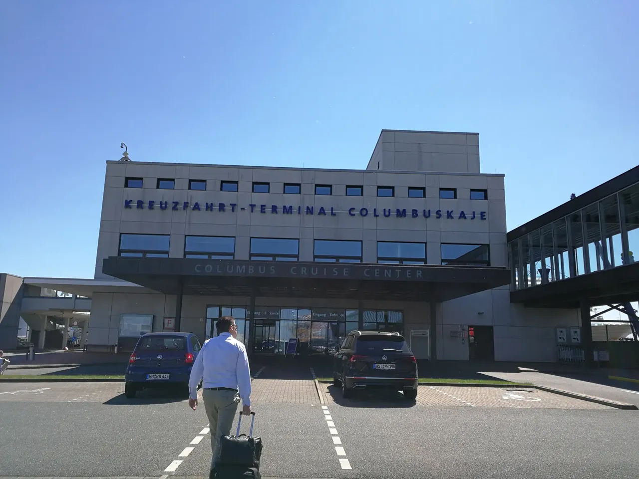 Kreuzfahrt-Terminal Columbuskaje in Bremerhaven, davor ein Mann mit Koffer